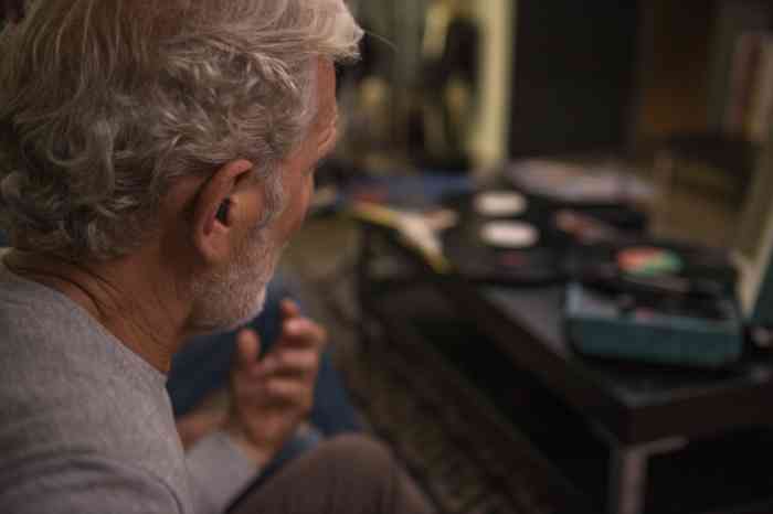 Hombre mayor escuchando música con su audífono intrauricular