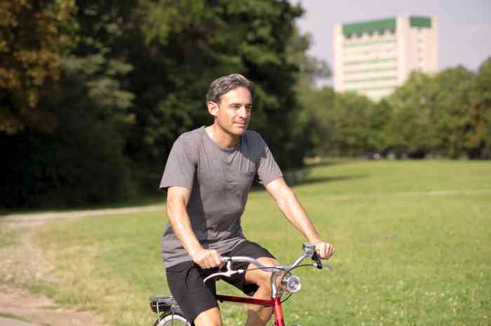 Un hombre con su bicicleta en un parque