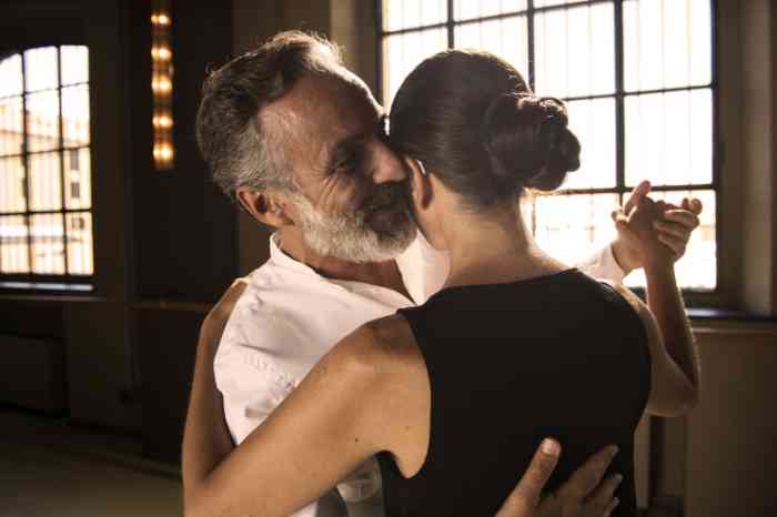 Mujer con audífono auricular en el canal baila el tango con su pareja
