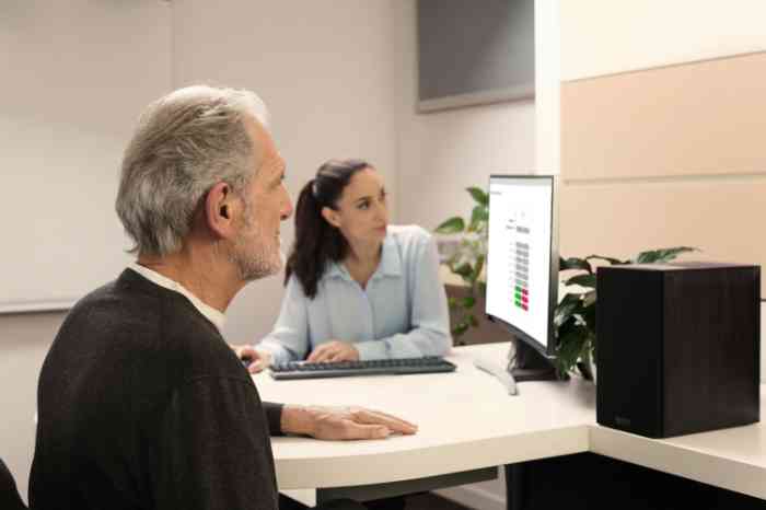 Dos clientes hablan con una audioprotesista antes de una prueba auditiva