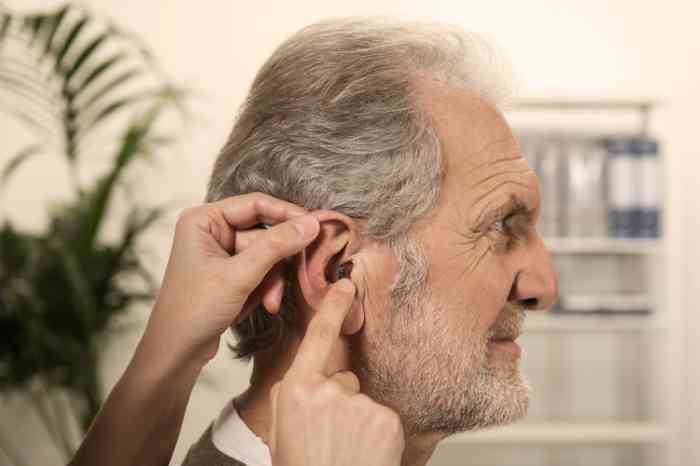 Perfil de un hombre mayor con audífono intrauricular en el oído