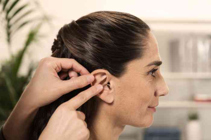 Perfil de una mujer con audífono auricular en el canal