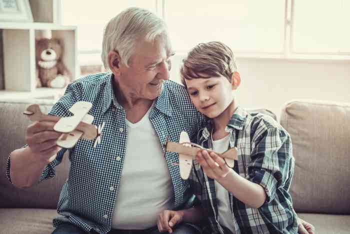 Un abuelo y su nieto hablan sentados en un sofá