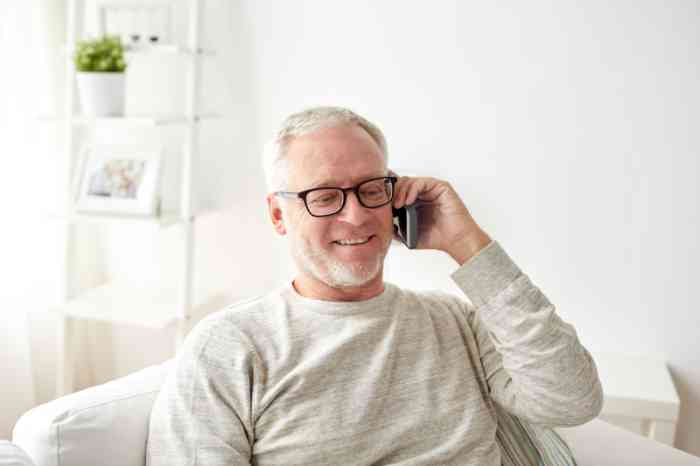 Un hombre habla por teléfono con su dispositivo para mayores