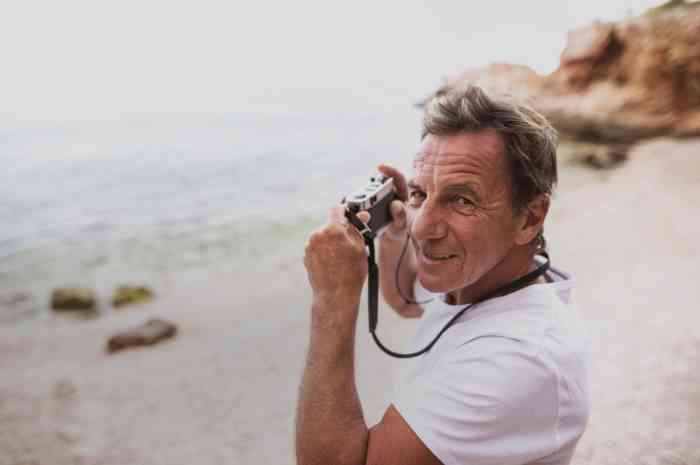 Un hombre toma fotos del mar en la playa