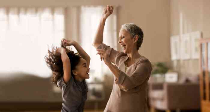 Una abuela baila con su nieta en el salón de su casa