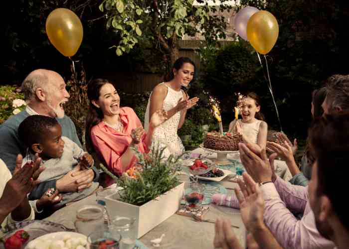 Una familia feliz celebrando fiesta de cumpleaños de la niña afuera