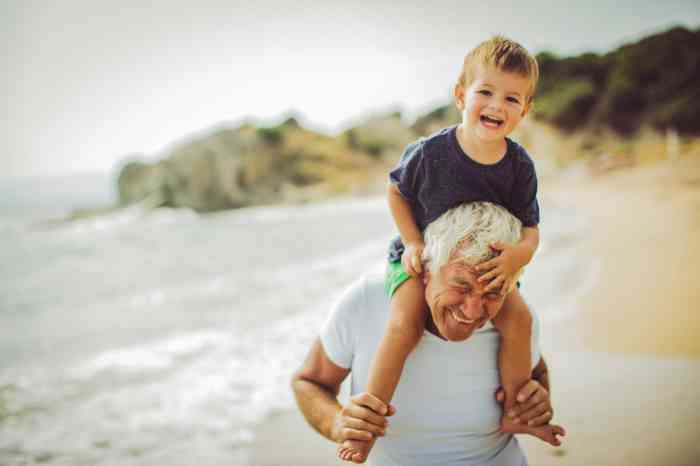 Un abuelo juega con su nieto en la playa