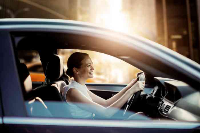 Perfil de una mujer que sonríe conduciendo su coche