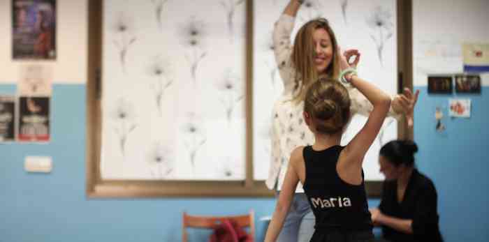 Una niña y su profesora bailan en la clase